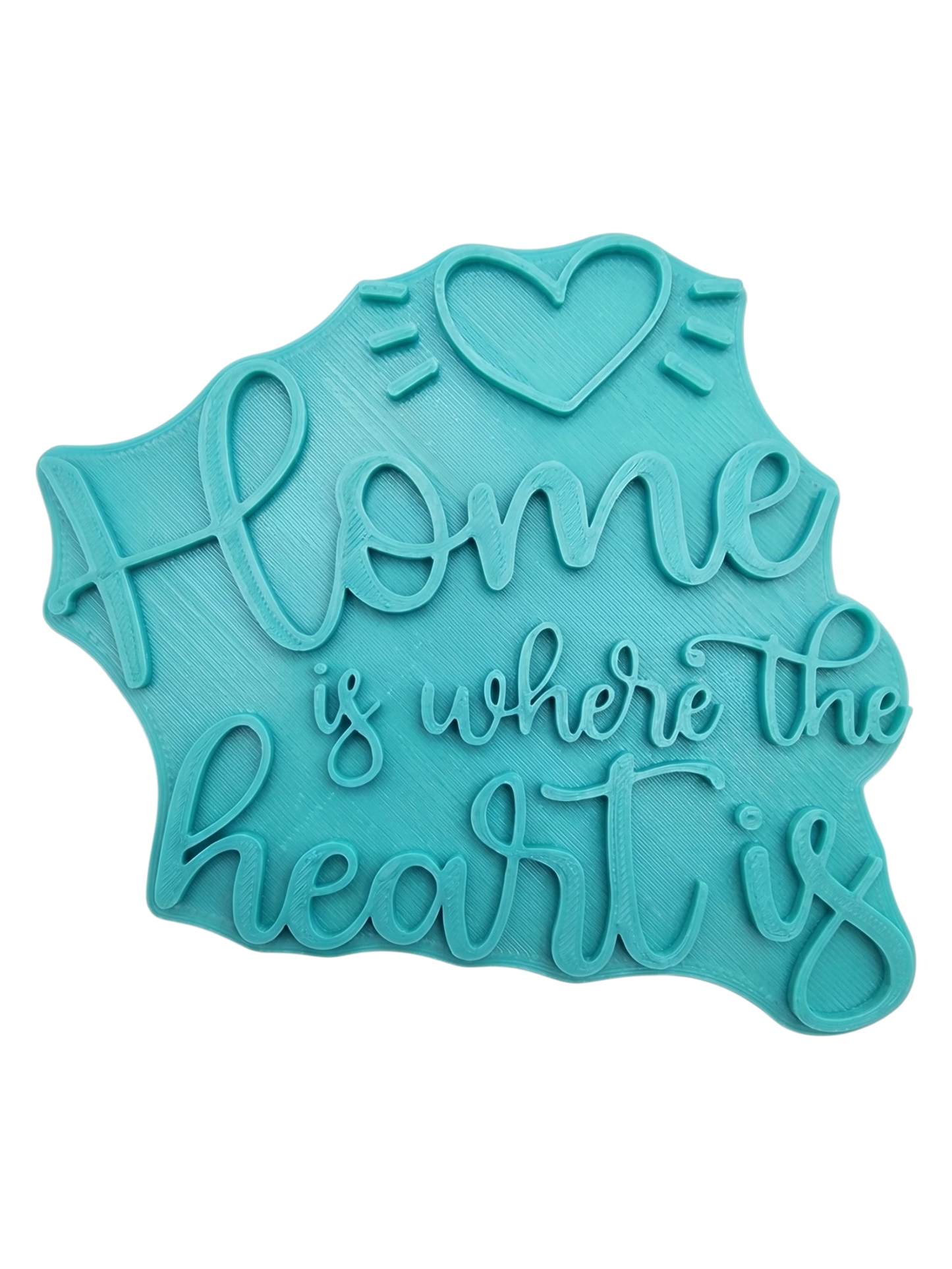 Blaugrüner Textstempel für Ton mit dem Spruch 'Home is where the heart is' und einem Herz-Motiv. Hochwertiges Werkzeug für saubere Prägungen in Keramik.
