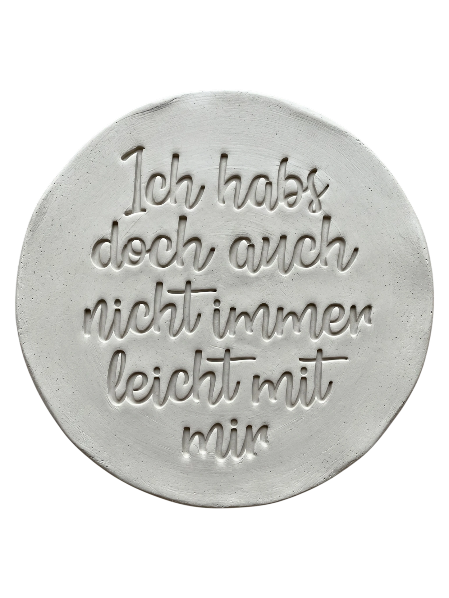 Präziser Stempelabdruck in hellem Ton. Die schwungvolle Handschrift erzeugt ein sauberes Relief auf der runden Tonplatte. Ideal für witzige Keramik-Geschenke.