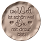 Perfekter Abdruck im Ton mit dem Spruch 'Die Welt ist schön weil Du mit drauf bist!'. Erstellt mit einem MinseArt Keramikstempel. Eine kreative Töpfer-Idee für Geschenke an Lieblingsmenschen, mit präzisen Konturen und feinen Herz-Details.