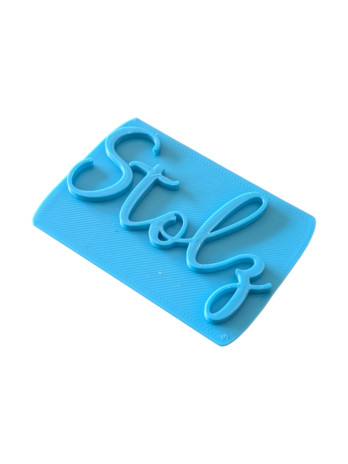 Schräge Nahaufnahme des blauen Tonstempels Stolz mit klaren Relief-Kanten.