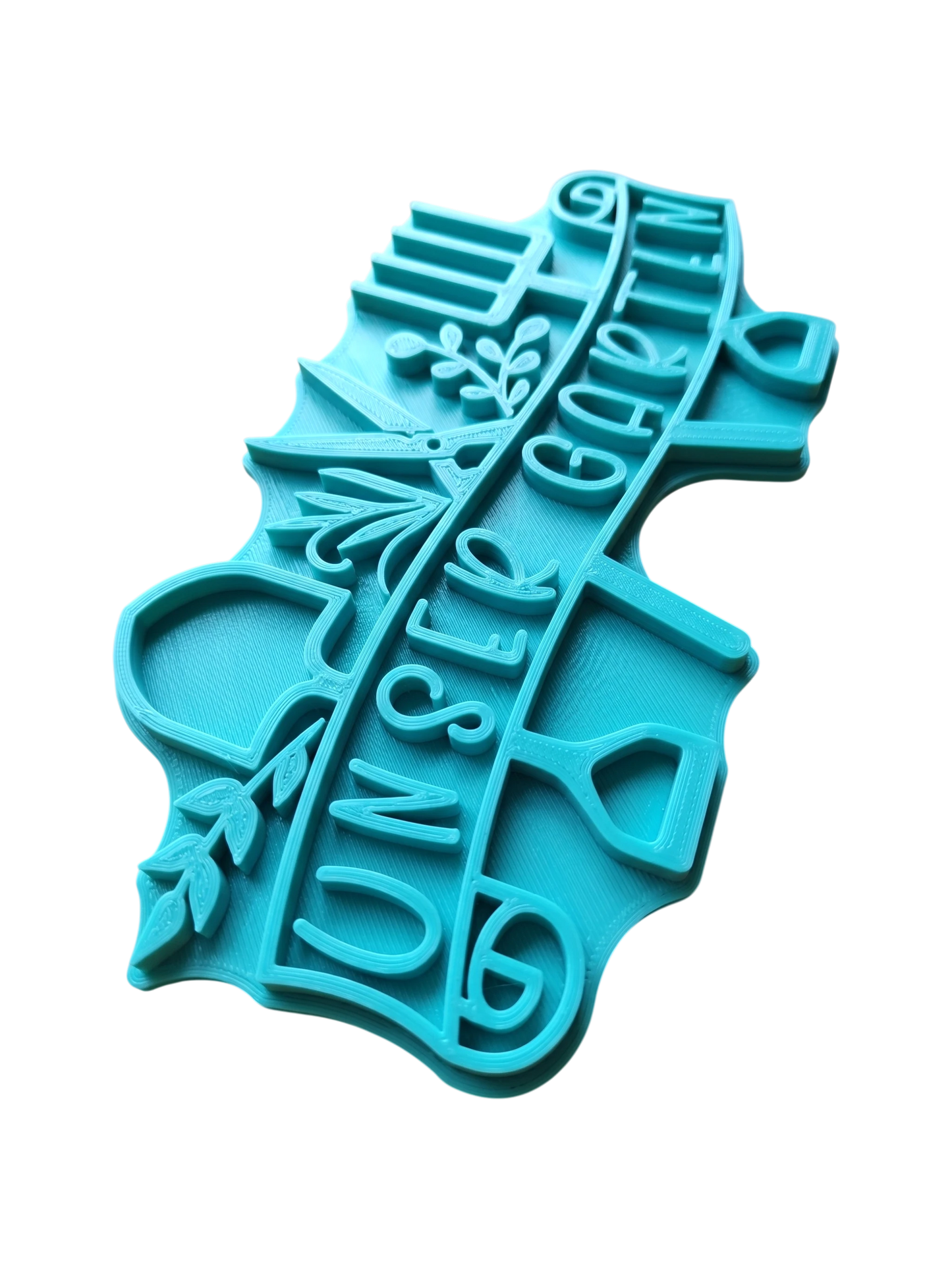 Türkisfarbener Keramikstempel für Ton mit dem Schriftzug "unser Garten" auf einem Banner, umrahmt von Schaufel, Gartenschere und Grabegabel. Detailreicher Prägestempel für kreative Töpfer-Ideen.