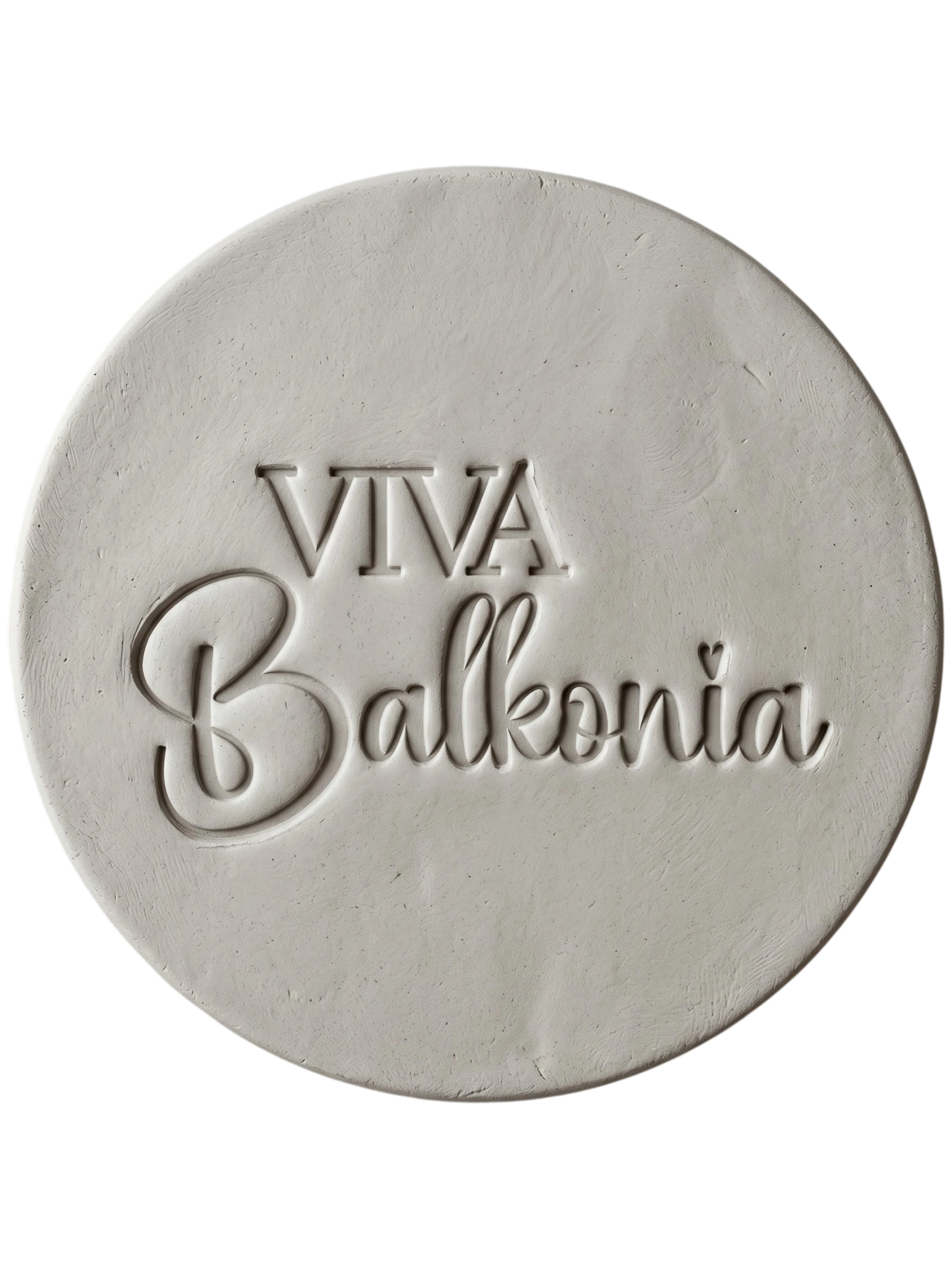Präziser Stempelabdruck des Schriftzugs 'VIVA Balkonia' in hellem Ton. Das saubere, tiefe Relief auf der runden Tonplatte zeigt die harmonische Kombination aus klarer Druckschrift und verspielter Schreibschrift mit einem kleinen Herz-Detail über dem i. Ein perfektes Töpfer-Ergebnis mit einem MinseArt Keramikstempel.
