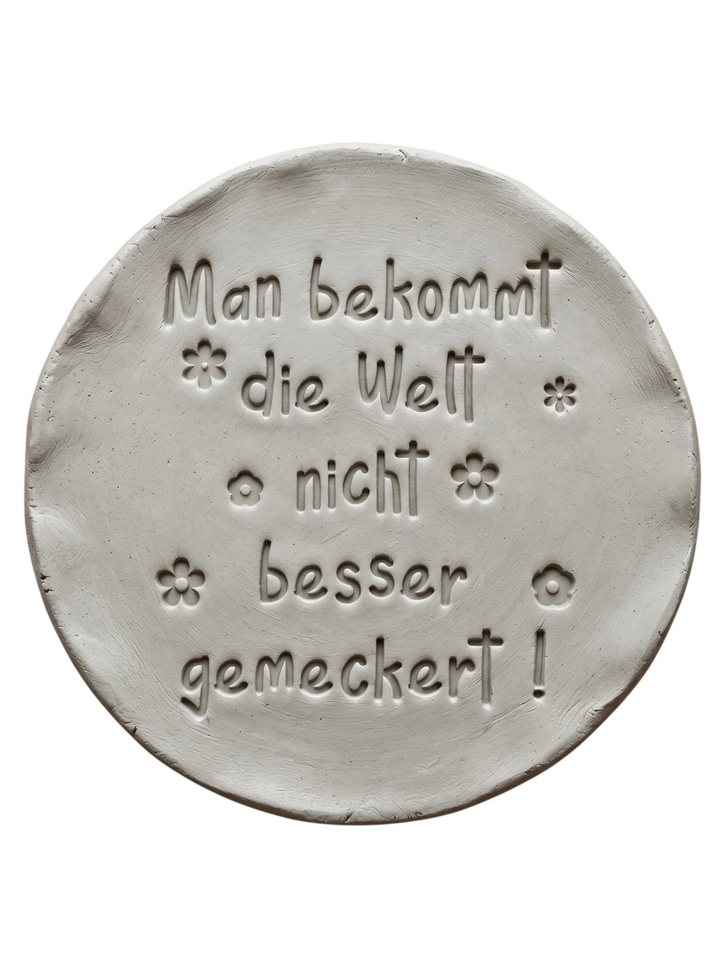 Präziser Stempelabdruck des Spruchs 'Man bekommt die Welt nicht besser gemeckert!' in hellem Ton mit kleinen Blumen-Details. Ein sauberes Relief auf einer runden Tonplatte, erstellt mit einem MinseArt Keramikstempel.
