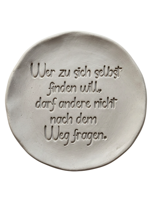 Präziser Stempelabdruck einer Lebensweisheit in hellem Ton. Die moderne, verspielte Schreibschrift erzeugt ein sauberes, tiefes Relief auf der runden Tonplatte – ideal für dekorative Achtsamkeits-Projekte.