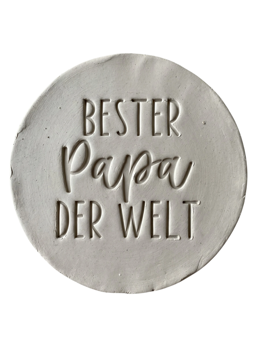 Detailreicher Stempelabdruck „Bester Papa der Welt“ in weißem Ton. Hochwertiger Keramikstempel von MinseArt für präzise Konturen – die perfekte Töpfer-Idee für handgefertigte Geschenke zum Vatertag und dein nächstes Projekt.