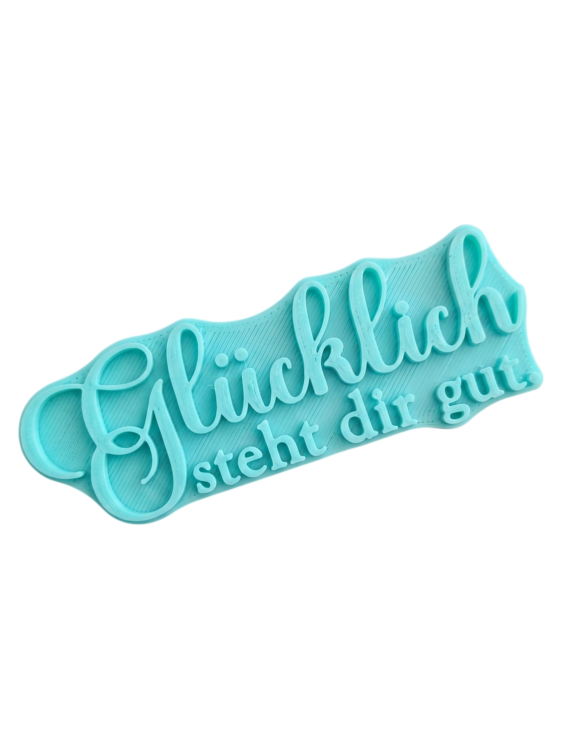 Türkisfarbener Textstempel für Ton mit dem Schriftzug 'Glücklich steht dir gut'. Hochwertiges Töpferwerkzeug von MinseArt für saubere Prägungen in Keramik.