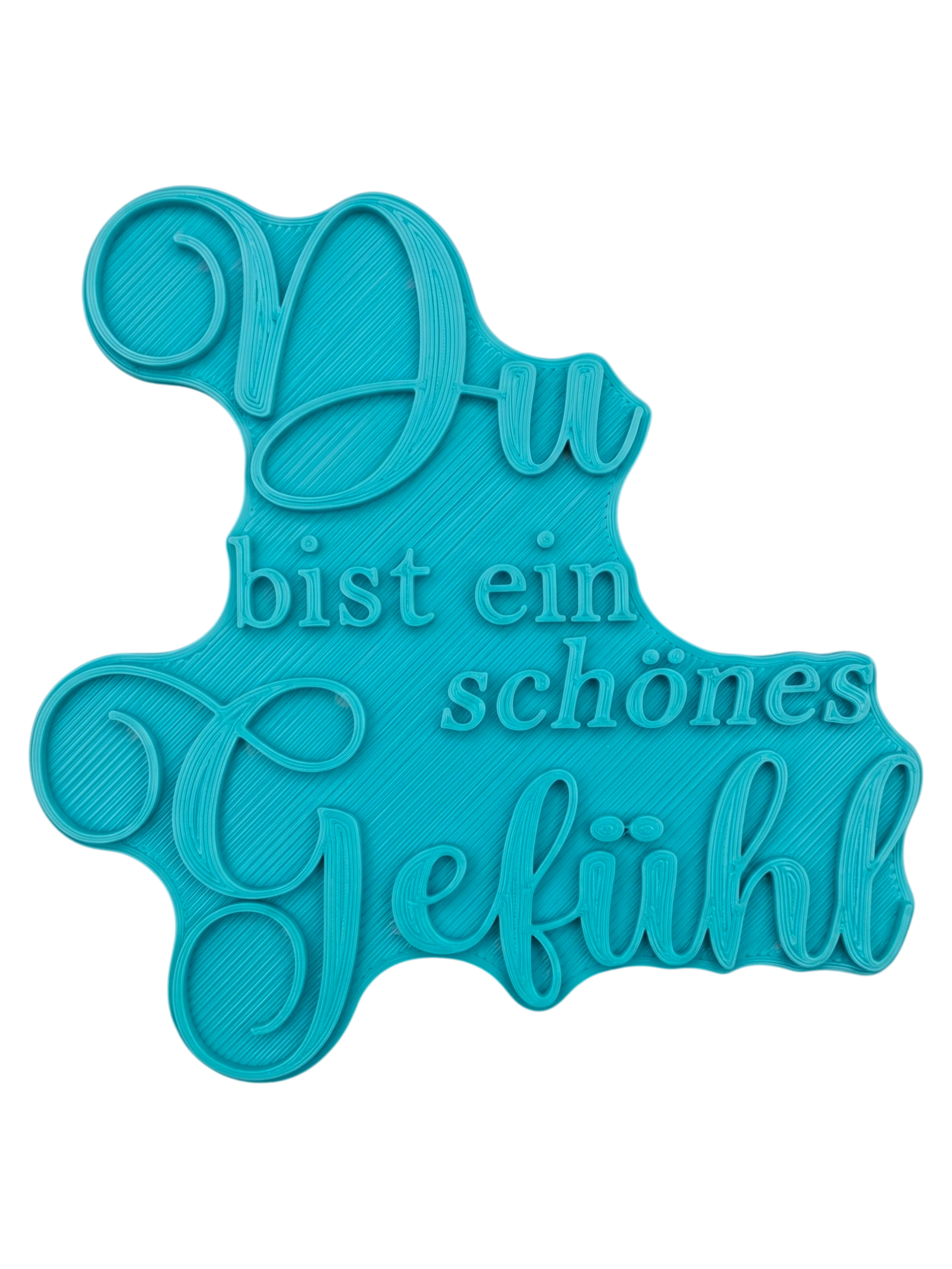 Präziser Stempelabdruck des Spruchs 'Du bist ein schönes Gefühl' in hellem Ton. Die elegante Kombination aus schwungvoller Schreibschrift und klassischer Serifenschrift erzeugt ein tiefes Relief auf der runden Tonplatte.