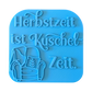 Direkte Draufsicht auf den freigestellten blauen Tonstempel Herbstzeit ist Kuschelzeit mit Sessel-Illustration.