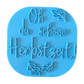 Direkte Draufsicht auf den freigestellten blauen Tonstempel Oh du schöne Herbstzeit mit Herbstblättern.