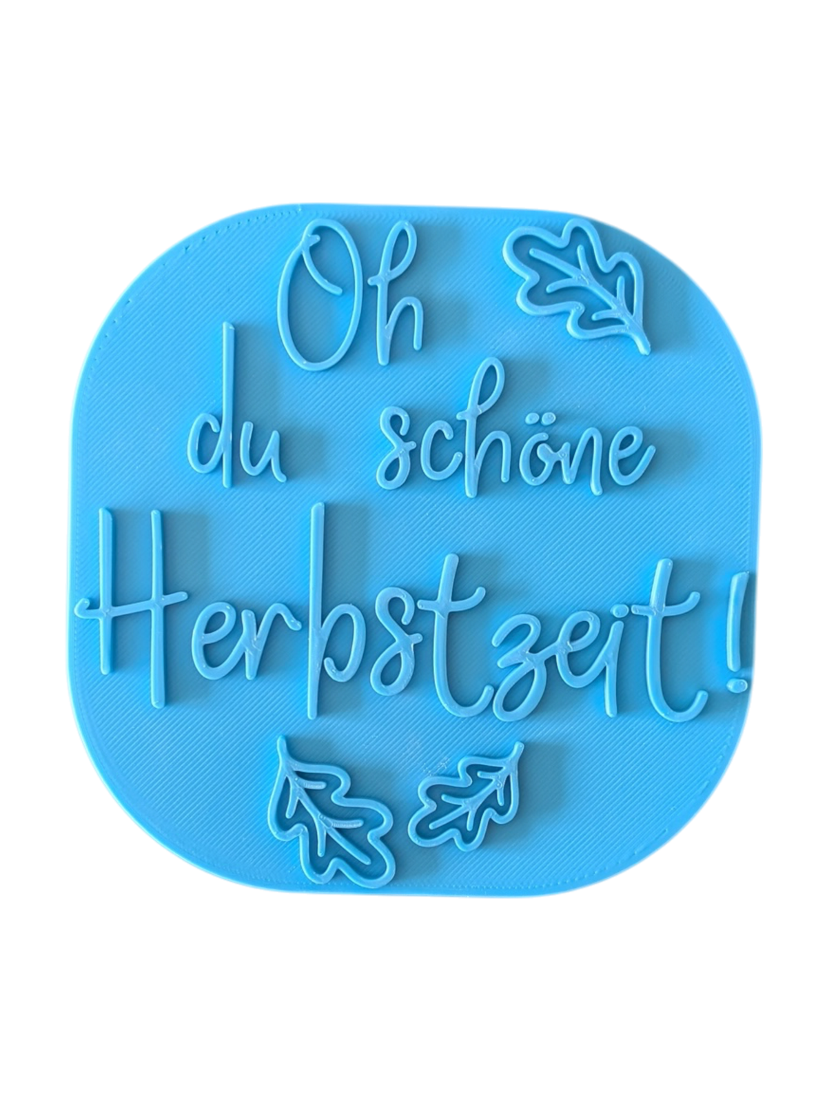 Direkte Draufsicht auf den freigestellten blauen Tonstempel Oh du schöne Herbstzeit mit Herbstblättern.