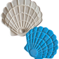 Draufsicht auf den blauen Muschel-Stempel von MinseArt neben einem perfekten hellen Tonabdruck mit kleiner Perle, auf schwarzem Hintergrund.