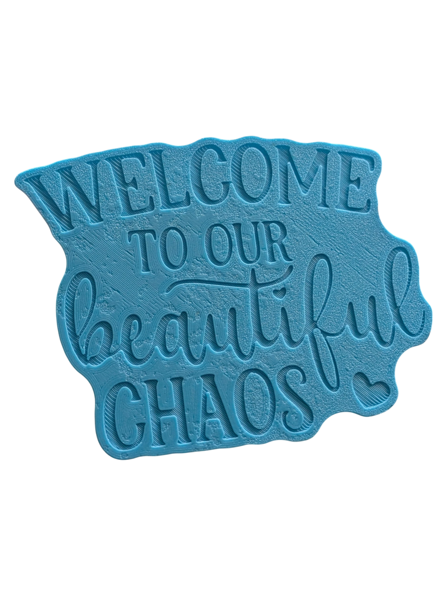 Schrägansicht des Tonstempels „Welcome to our beautiful chaos“. Ein hochwertiges Töpferwerkzeug mit tiefem Profil für gestochen scharfe Schriftzüge in der Modelliermasse.