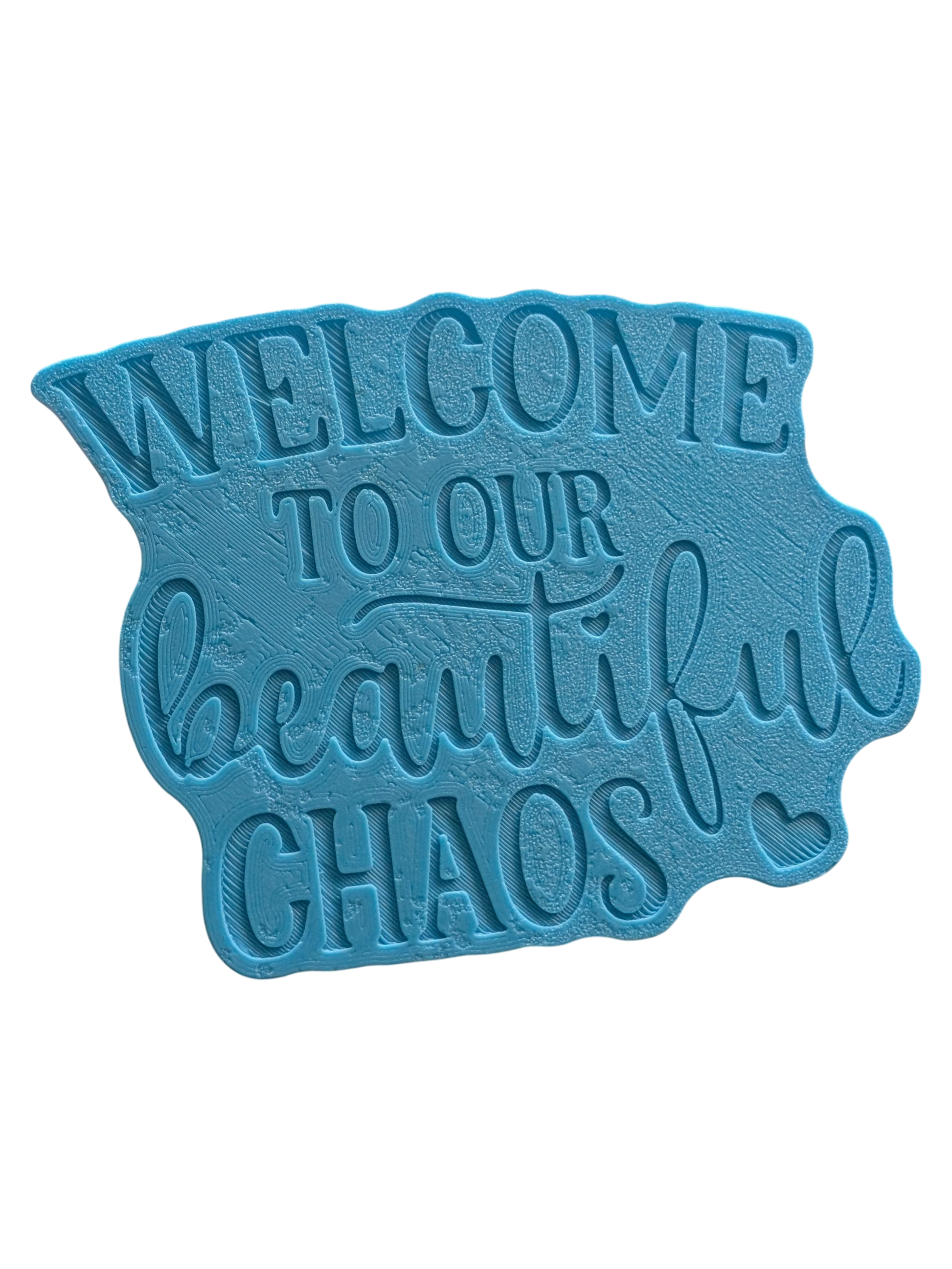 Schrägansicht des Tonstempels „Welcome to our beautiful chaos“. Ein hochwertiges Töpferwerkzeug mit tiefem Profil für gestochen scharfe Schriftzüge in der Modelliermasse.