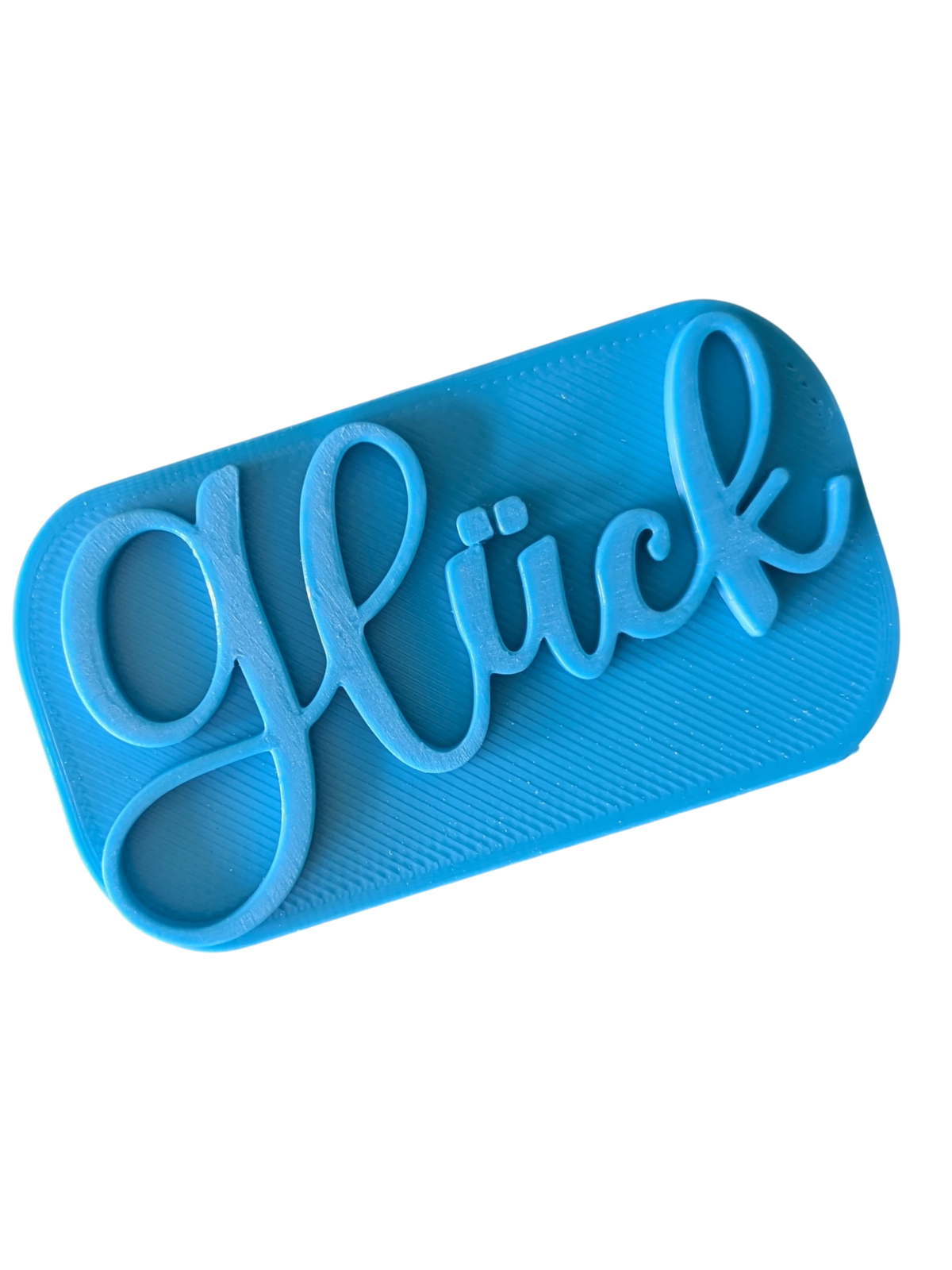 Direkte Draufsicht auf den blauen Tonstempel mit dem Schriftzug Glück und klaren Konturen.
