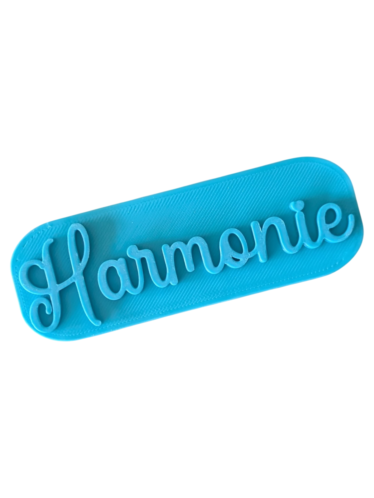 Direkte Draufsicht auf den blauen Tonstempel Harmonie mit liebevollen Details wie dem Herz am i-Punkt.