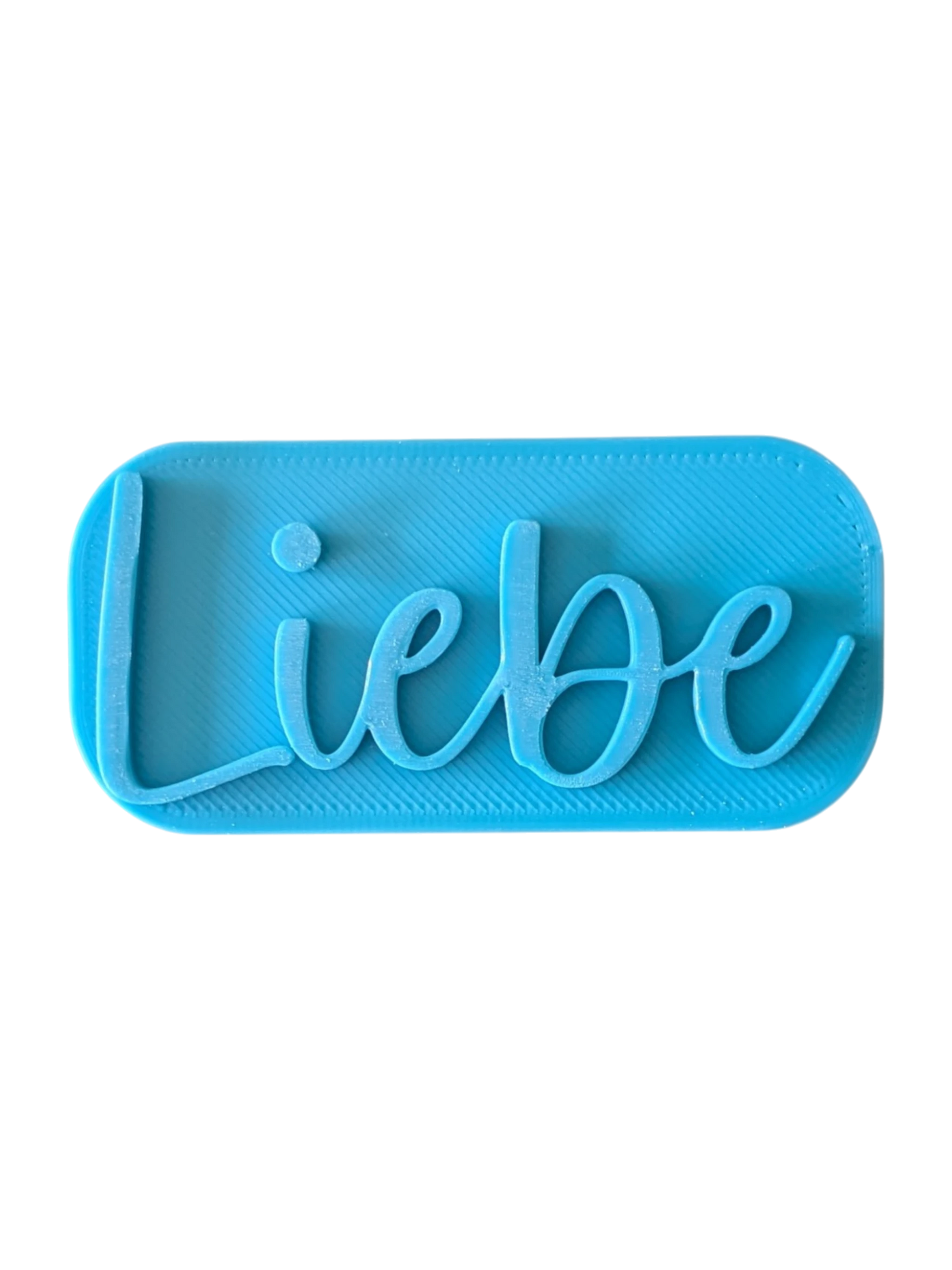 Direkte Draufsicht auf den blauen Tonstempel mit dem Schriftzug Liebe und klaren Konturen für Tonprojekte.