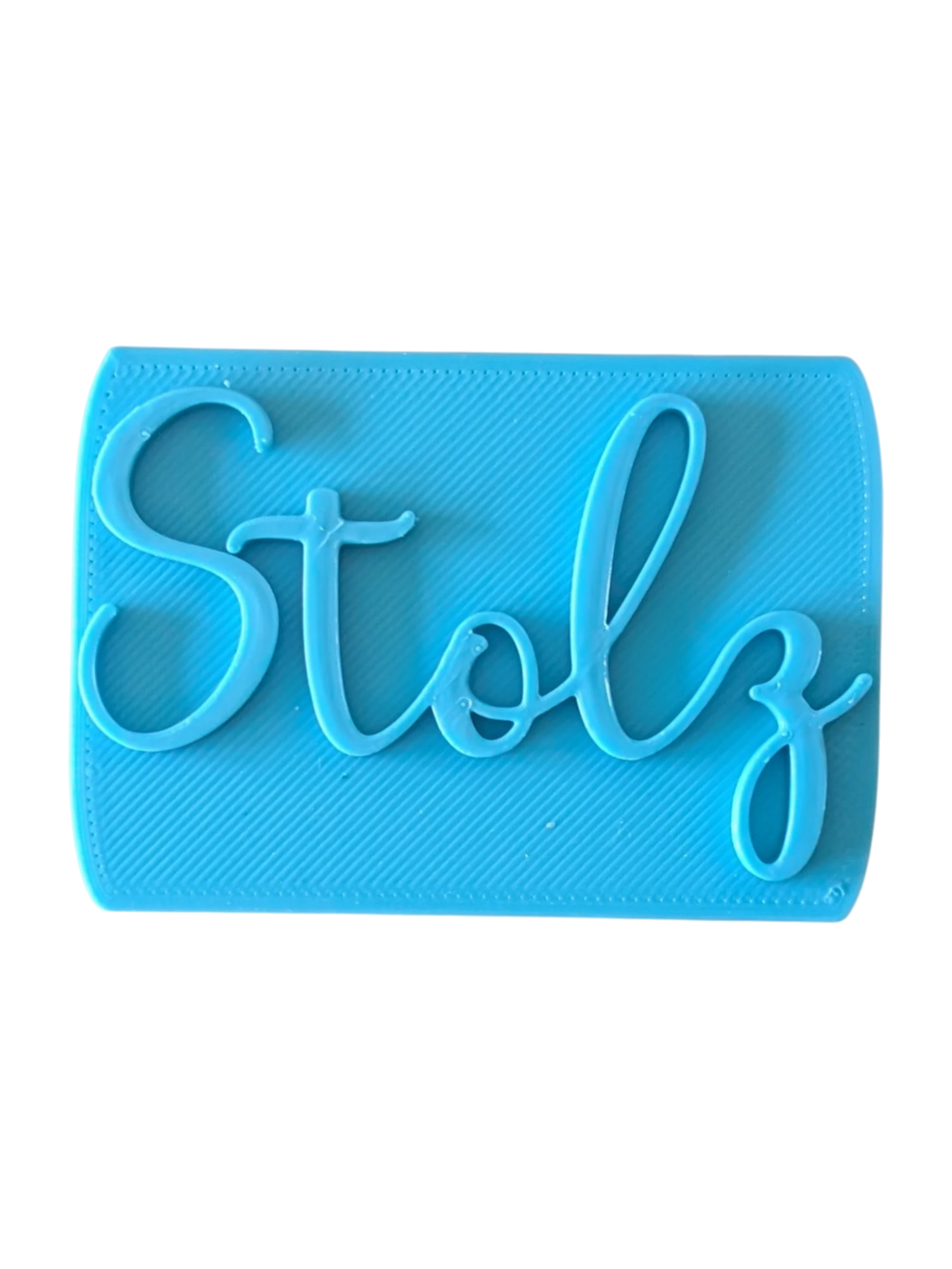 Direkte Draufsicht auf den blauen Tonstempel mit dem Schriftzug Stolz und präzisen Konturen.