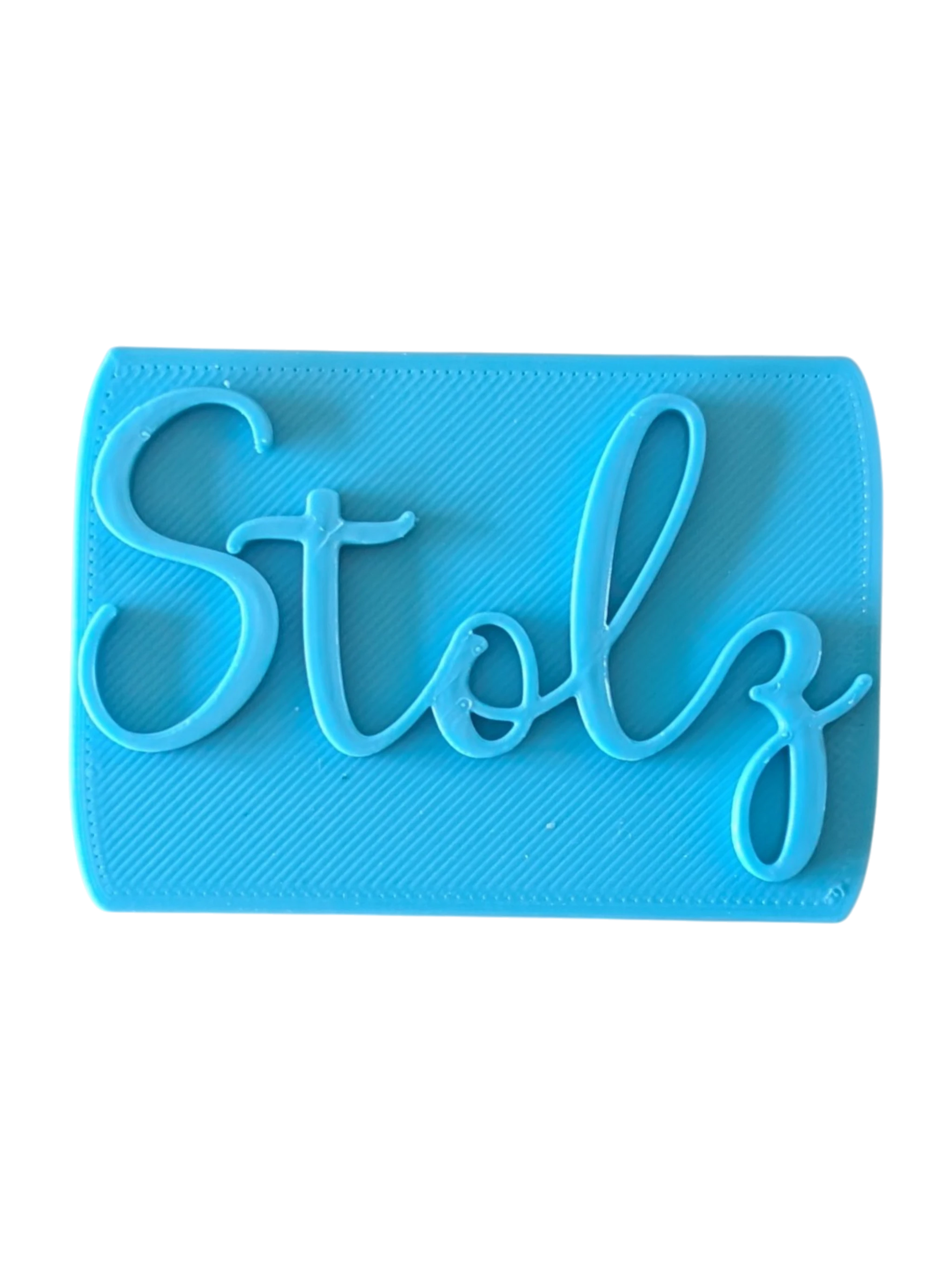 Direkte Draufsicht auf den blauen Tonstempel mit dem Schriftzug Stolz und präzisen Konturen.