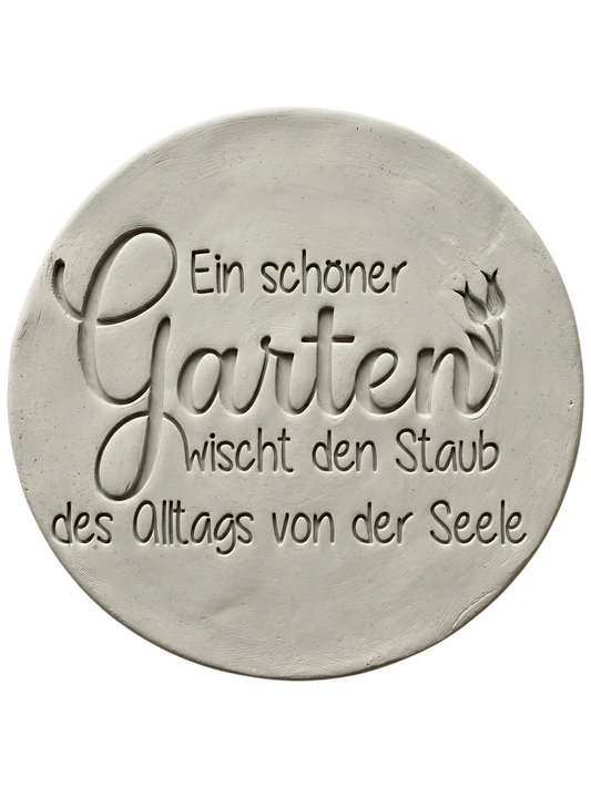 Präziser Stempelabdruck des Spruchs 'Ein schöner Garten wischt den Staub des Alltags von der Seele' in hellem Ton. Sauberes und tiefes Relief auf einer runden Tonplatte.