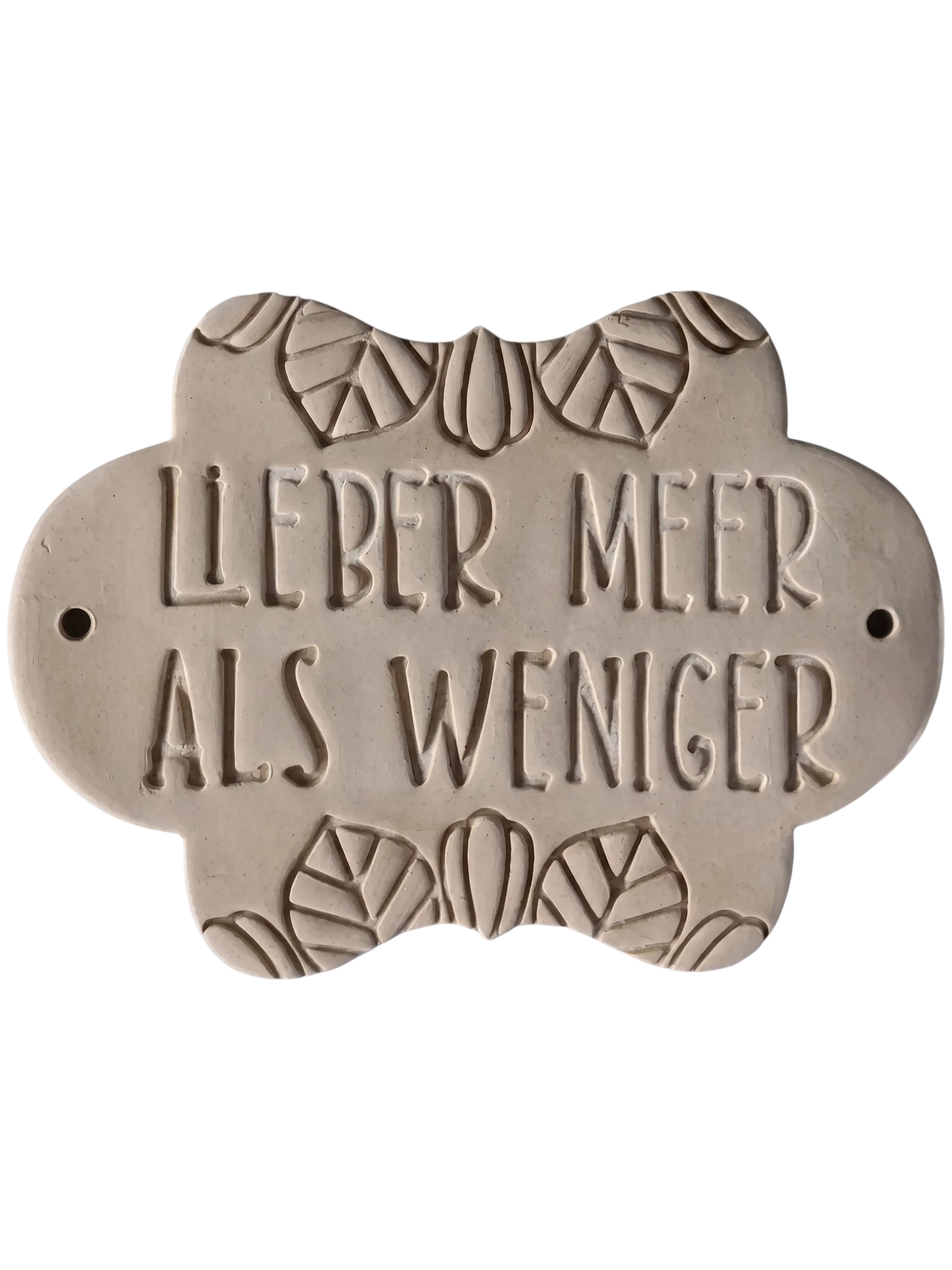 Detailreicher Stempelabdruck des Spruchs 'Lieber Meer als weniger' in weichem Ton. Das saubere Relief auf der verzierten Tonplatte zeigt die präzisen Konturen des Keramikstempels.