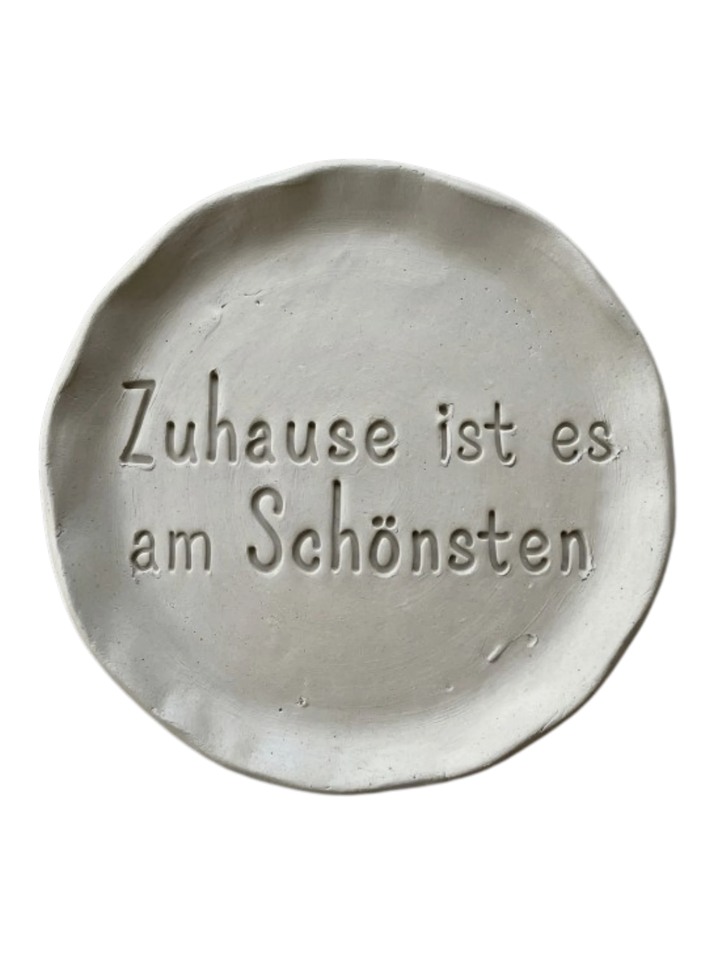 Detailreicher Stempelabdruck des Spruchs Zuhause ist es am Schönsten in hellem Ton. Das saubere Relief auf der runden Tonplatte zeigt präzise Konturen für dekorative Keramikprojekte.