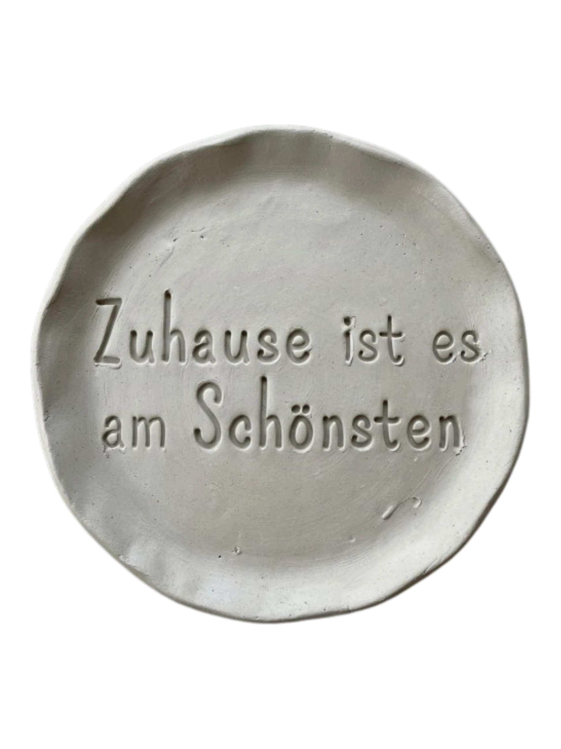 Detailreicher Stempelabdruck des Spruchs Zuhause ist es am Schönsten in hellem Ton. Das saubere Relief auf der runden Tonplatte zeigt präzise Konturen für dekorative Keramikprojekte.