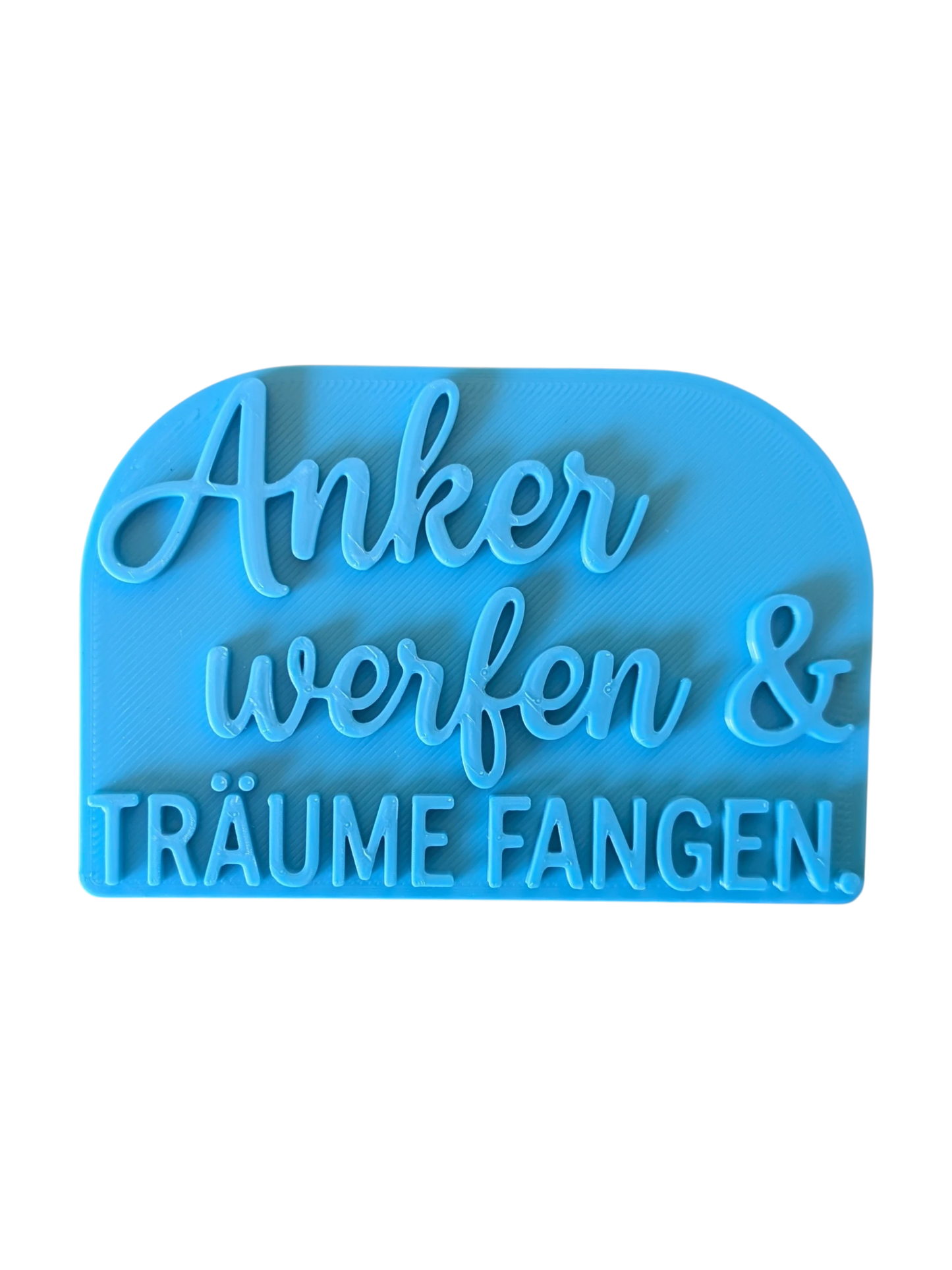 Draufsicht auf den türkisfarbenen Prägestempel für Ton mit dem Spruch 'Anker werfen & TRÄUME FANGEN.'. Ein maritimer Textstempel mit tiefem Relief für Keramik.
