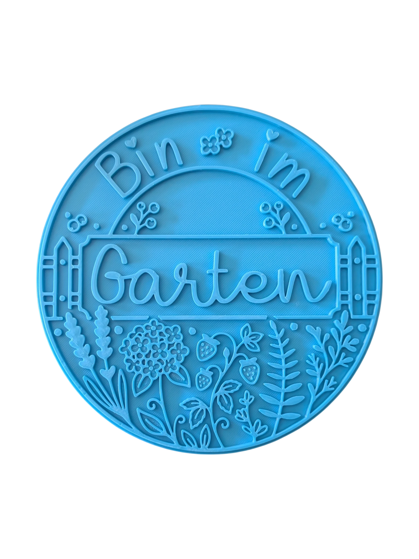 Draufsicht auf den Prägestempel für Ton mit dem Spruch 'Bin im Garten'. Das sommerliche Motiv kombiniert den Text mit einem Zaun, Erdbeeren, Lavendel und filigranen Blüten.