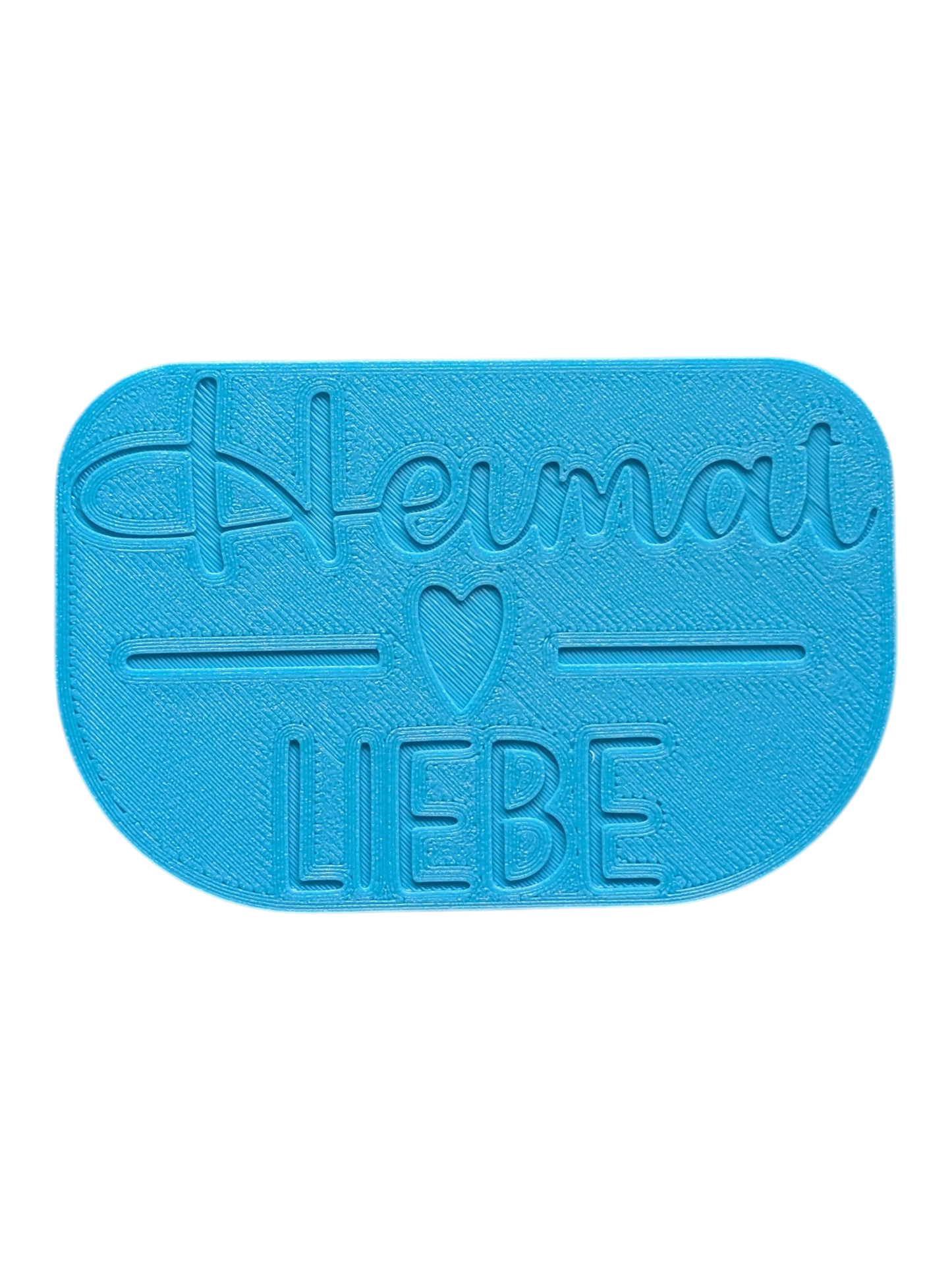 Türkisfarbener Textstempel 'Heimatliebe'. Der Keramikstempel verfügt über eine Positionierungshilfe auf der Rückseite für exaktes und gerades Stempeln auf dem Tonstück.