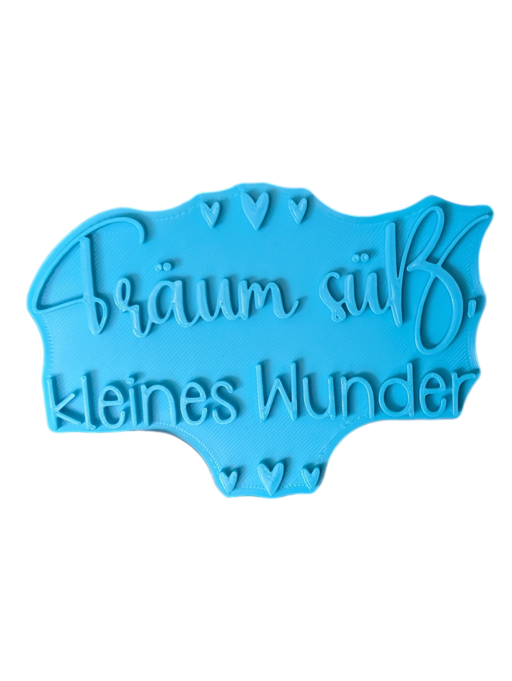 Draufsicht auf den Prägestempel für Ton mit dem Schriftzug 'Träum süß, kleines Wunder'. Ein detailreicher Textstempel mit kleinen Herzen für handgemachte Baby-Keramik.