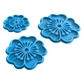 Perspektivische Detailansicht der drei blauen Blumen-Stempel für Töpferprojekte mit präzisen Konturen.