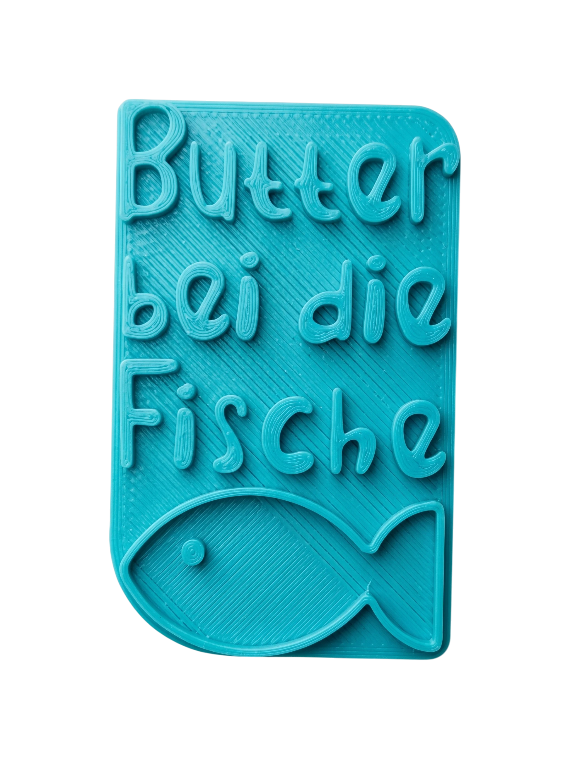 Türkisfarbener Keramikstempel für Ton mit dem Schriftzug 'Butter bei die Fische' und einem kleinen Fisch. Handgefertigtes Töpferwerkzeug für detailreiche Textprägungen.