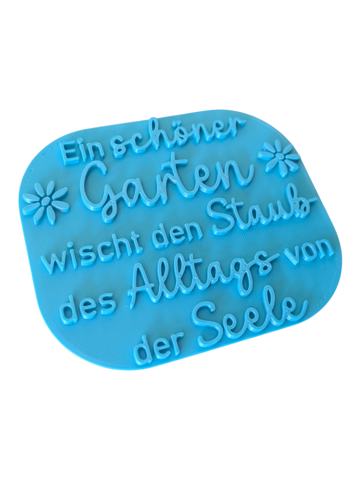 Schrägansicht des türkisfarbenen Tonstempels mit Garten-Spruch. Das großformatige Töpferwerkzeug besticht durch ein tiefes, exaktes Relief für perfekte Abdrücke beim Töpfern.