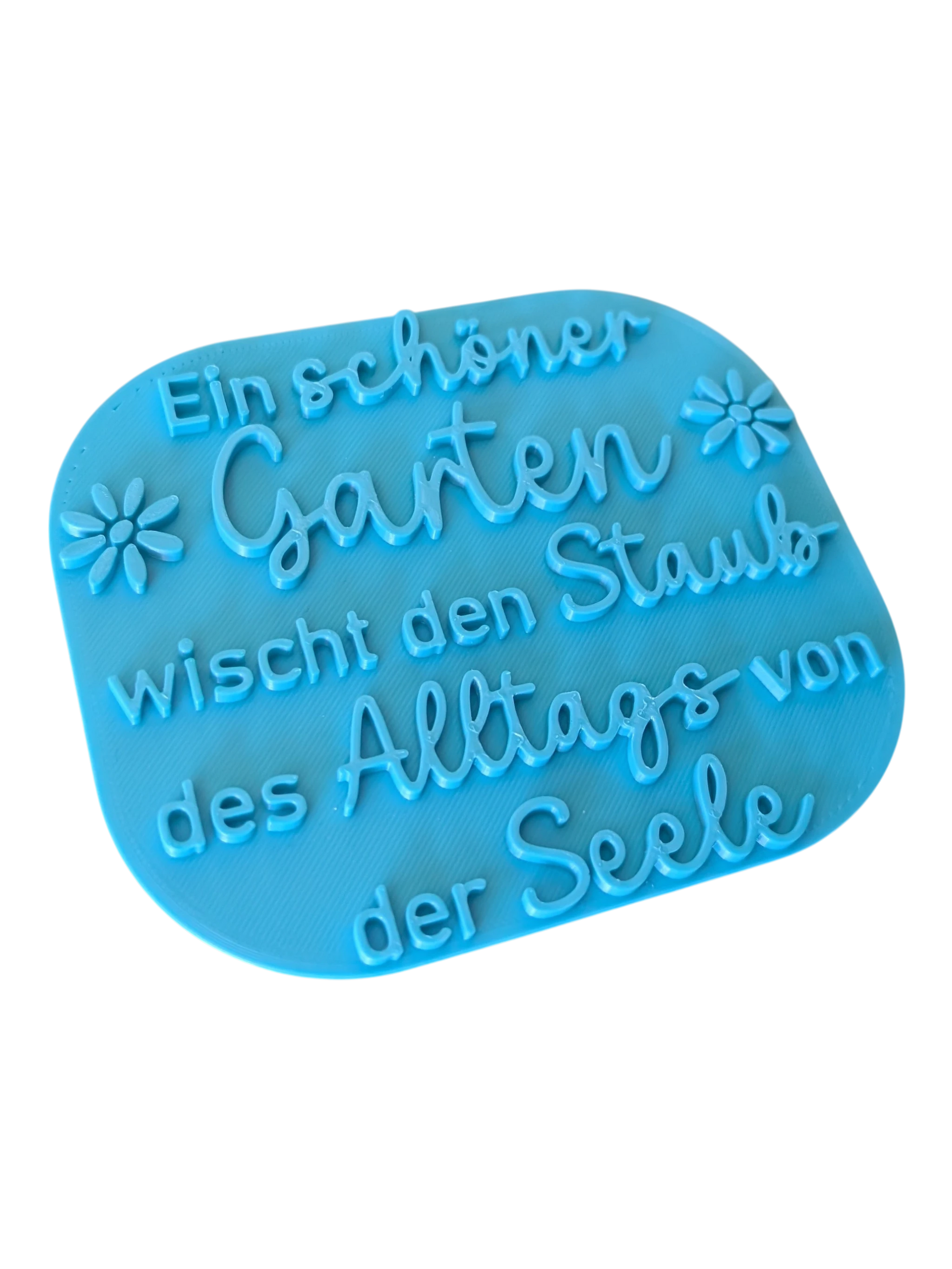 Schrägansicht des türkisfarbenen Tonstempels mit Garten-Spruch. Das großformatige Töpferwerkzeug besticht durch ein tiefes, exaktes Relief für perfekte Abdrücke beim Töpfern.