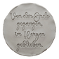 Präziser Stempelabdruck des Textstempels 'Von der Erde gegangen, im Herzen geblieben' in hellem Ton. Das detailreiche Relief zeigt die wunderschöne Schrift perfekt auf einer unglasierten, runden Tonplatte.