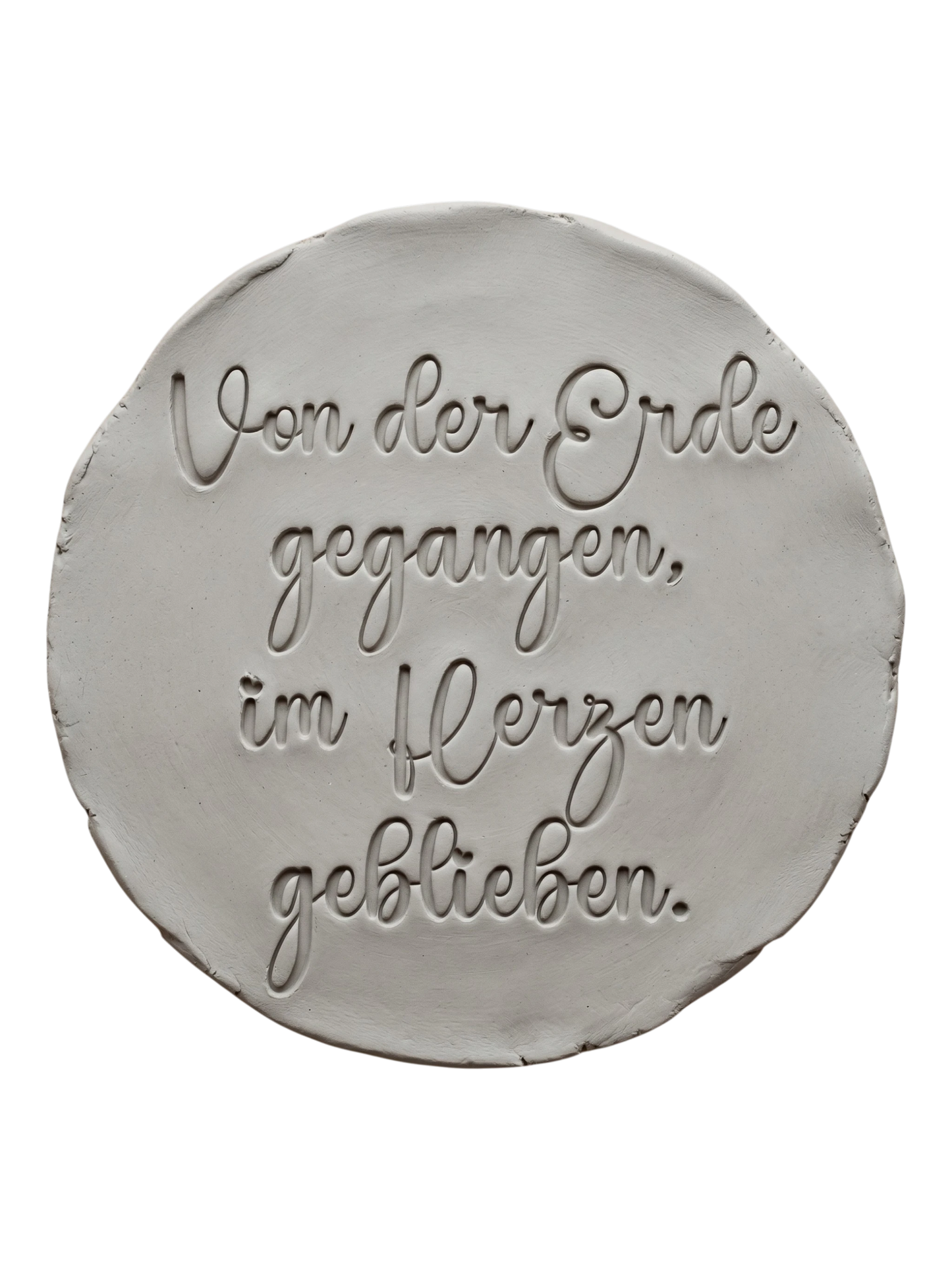 Präziser Stempelabdruck des Textstempels 'Von der Erde gegangen, im Herzen geblieben' in hellem Ton. Das detailreiche Relief zeigt die wunderschöne Schrift perfekt auf einer unglasierten, runden Tonplatte.