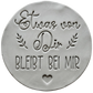 Präziser Stempelabdruck des Textstempels 'Etwas von dir bleibt bei mir' in hellem Ton. Das detailreiche Relief zeigt klare Schrift und florale Elemente perfekt auf einer unglasierten, runden Tonplatte.