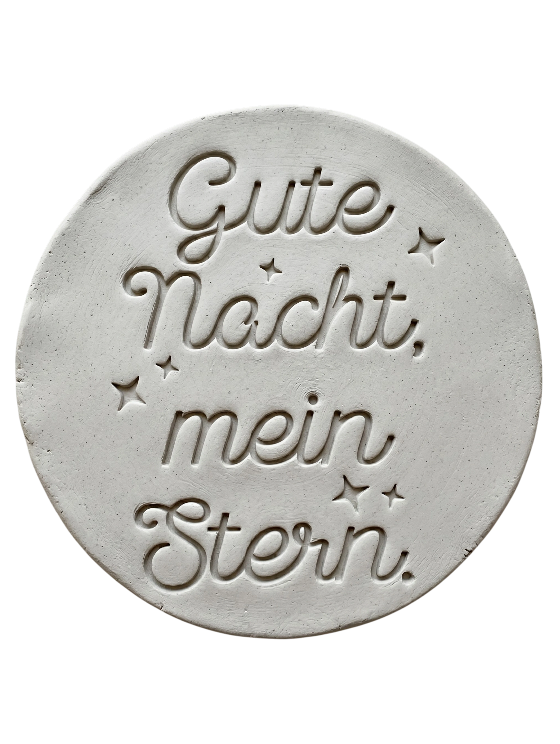 Sauberer Stempelabdruck des Textstempels in hellem, unglasiertem Ton. Die elegante Kombination aus Schrift und kleinen Sternen kommt auf der runden Tonplatte wunderschön zur Geltung.