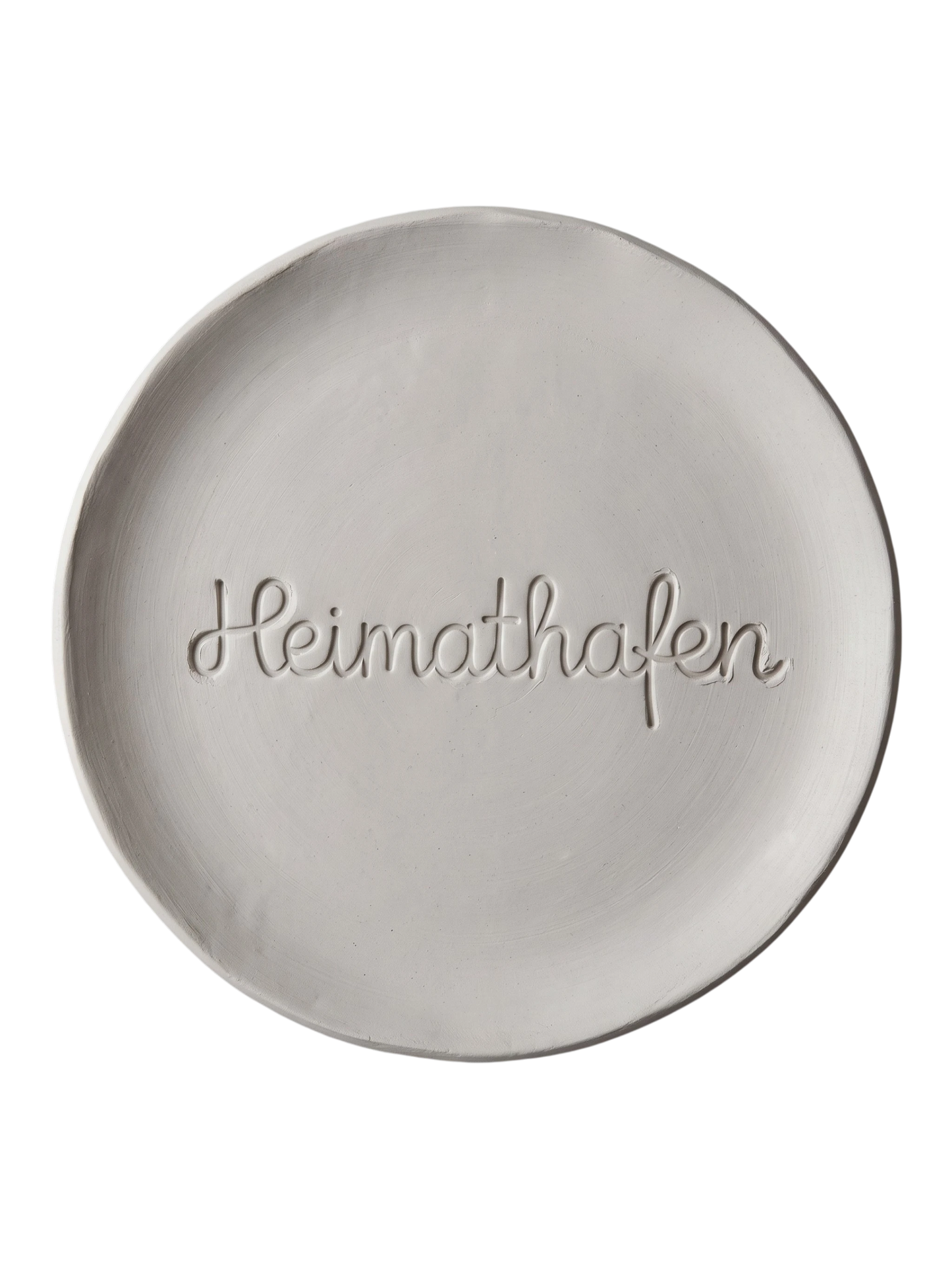 Sauberer Stempelabdruck des Textstempels 'Heimathafen' in hellem, unglasiertem Ton. Die fließende, zusammenhängende Schreibschrift kommt als tiefes Relief auf der runden Tonplatte perfekt zur Geltung.