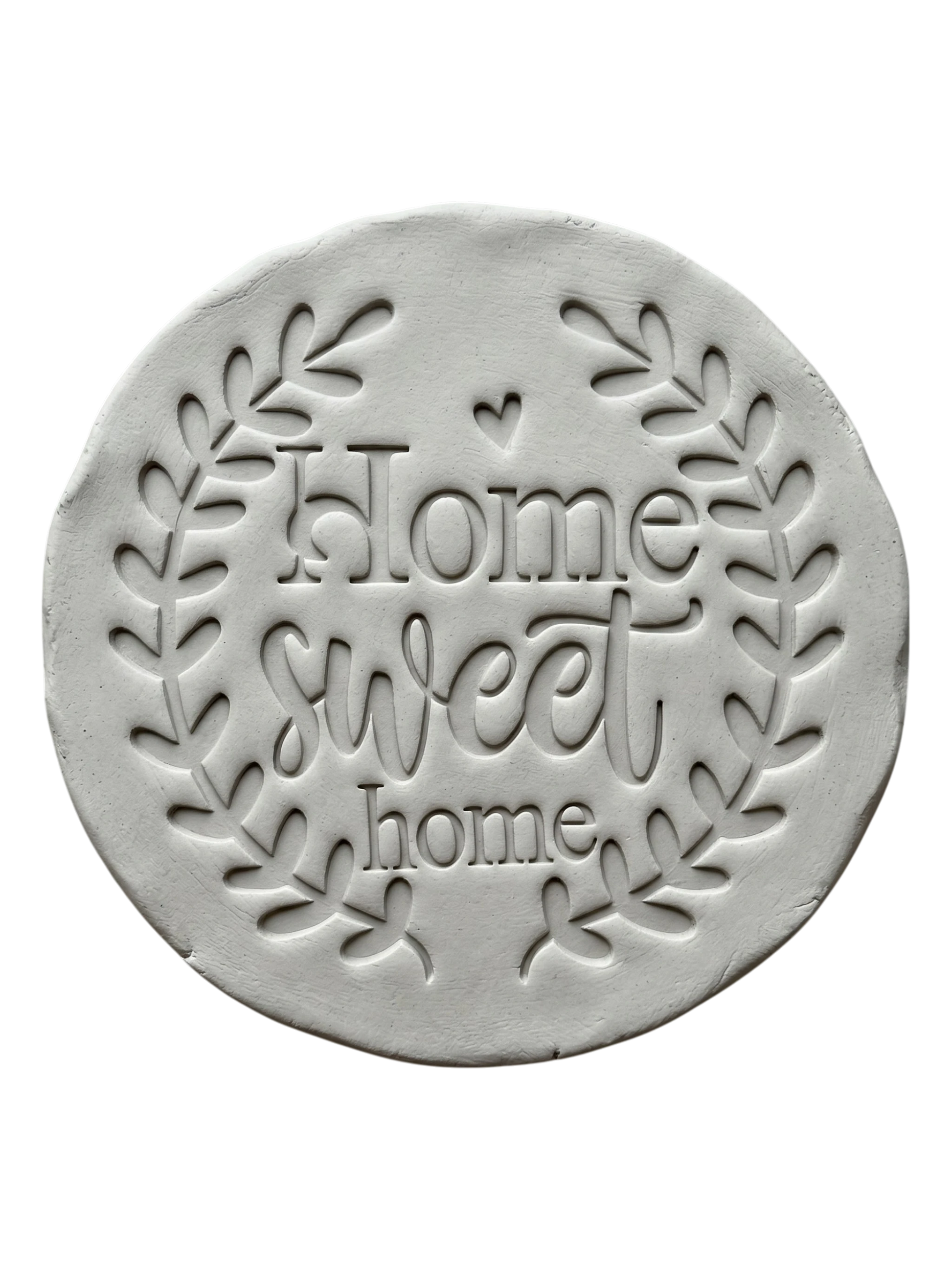 Sauberer Stempelabdruck des Prägestempels 'Home sweet home' in hellem Ton. Das detailreiche Relief zeigt den schönen Blätterkranz und den Schriftzug perfekt auf einer unglasierten, runden Tonplatte.