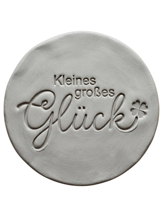 Sauberer Stempelabdruck des Textstempels in hellem, unglasiertem Ton. Die elegante, fließende Schreibschrift und das kleine Kleeblatt kommen auf der runden Tonplatte wunderschön zur Geltung.
