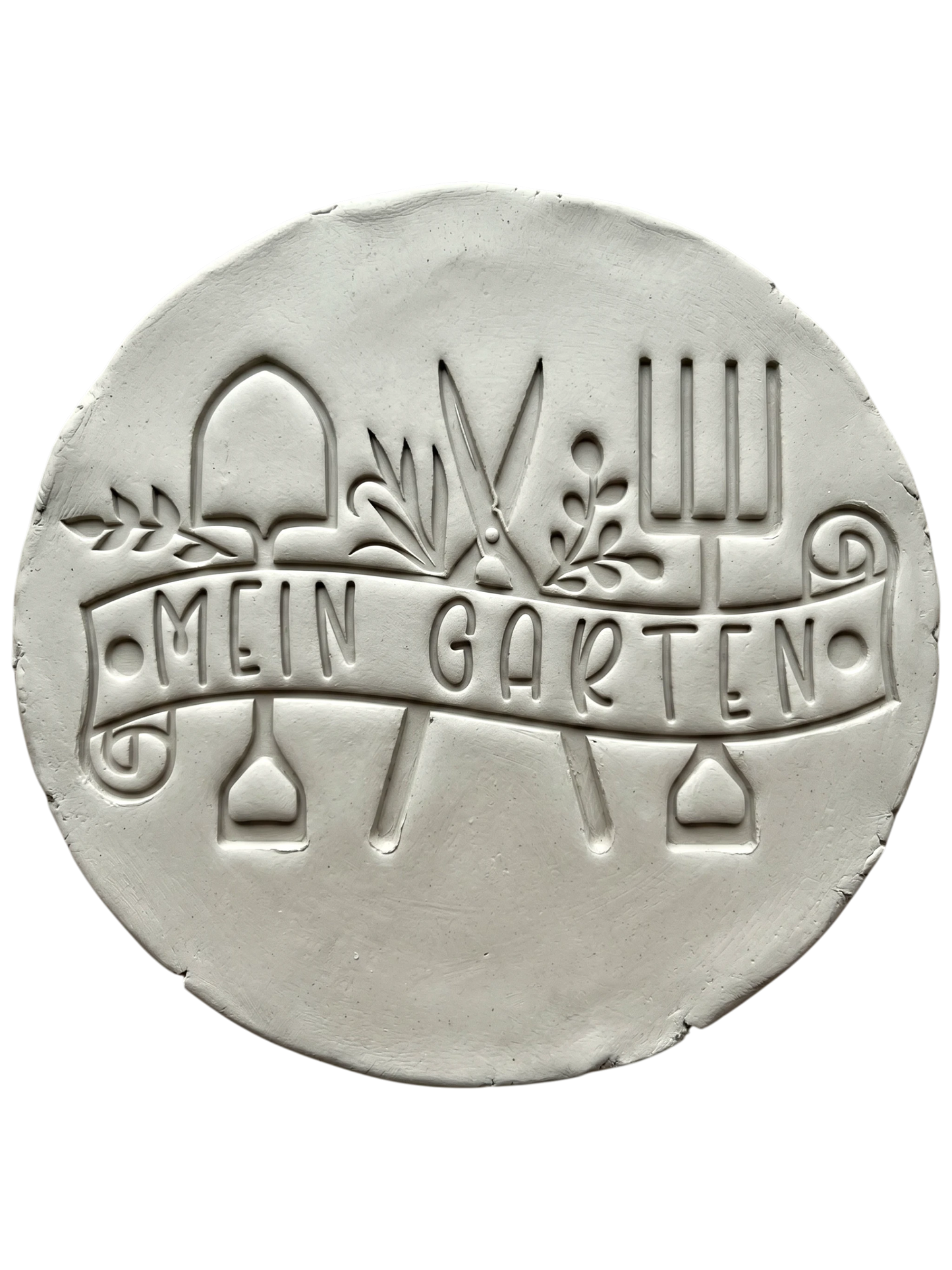 Präziser Stempelabdruck in hellem Ton mit dem Textstempel 'Mein Garten'. Das detailreiche Relief zeigt Gartengeräte und Pflanzenmotive auf einer handgemachten, runden Keramikplatte.