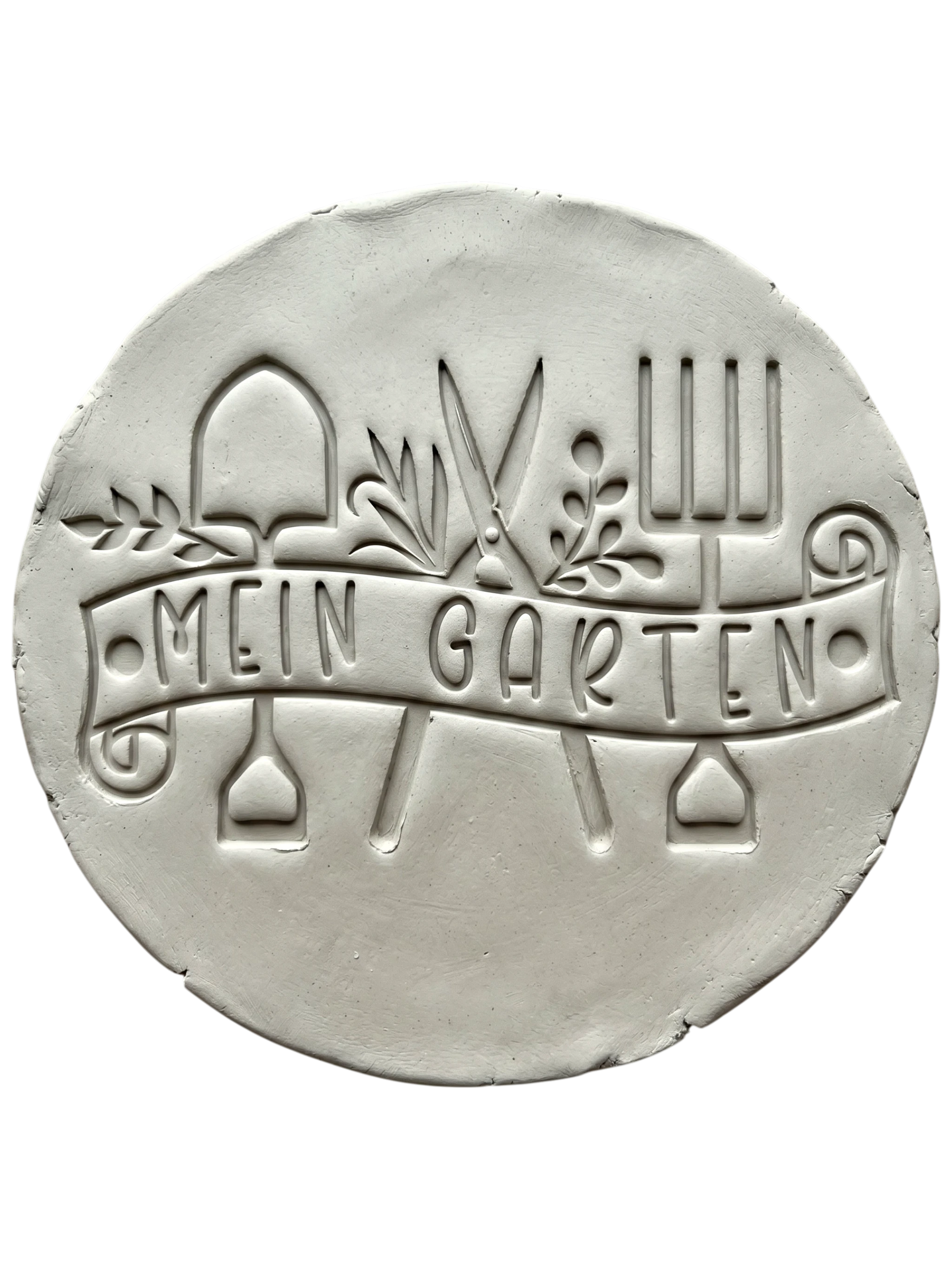 Präziser Stempelabdruck in hellem Ton mit dem Textstempel 'Mein Garten'. Das detailreiche Relief zeigt Gartengeräte und Pflanzenmotive auf einer handgemachten, runden Keramikplatte.