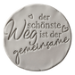 Sauberer Stempelabdruck des Textstempels in hellem Ton. Das detailreiche Relief zeigt den Spruch 'der schönste Weg ist der gemeinsame' mit kleinen Herzen auf einer unglasierten, runden Tonplatte.