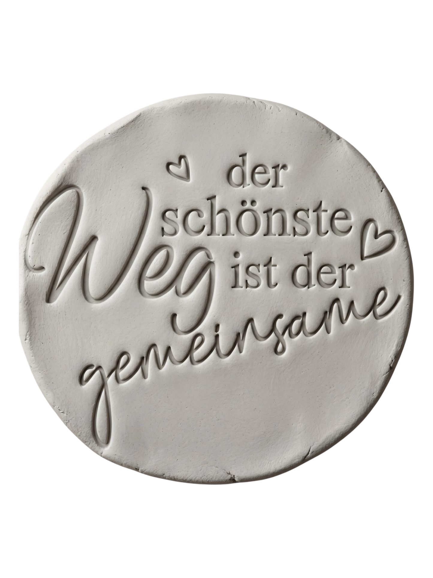 Sauberer Stempelabdruck des Textstempels in hellem Ton. Das detailreiche Relief zeigt den Spruch 'der schönste Weg ist der gemeinsame' mit kleinen Herzen auf einer unglasierten, runden Tonplatte.