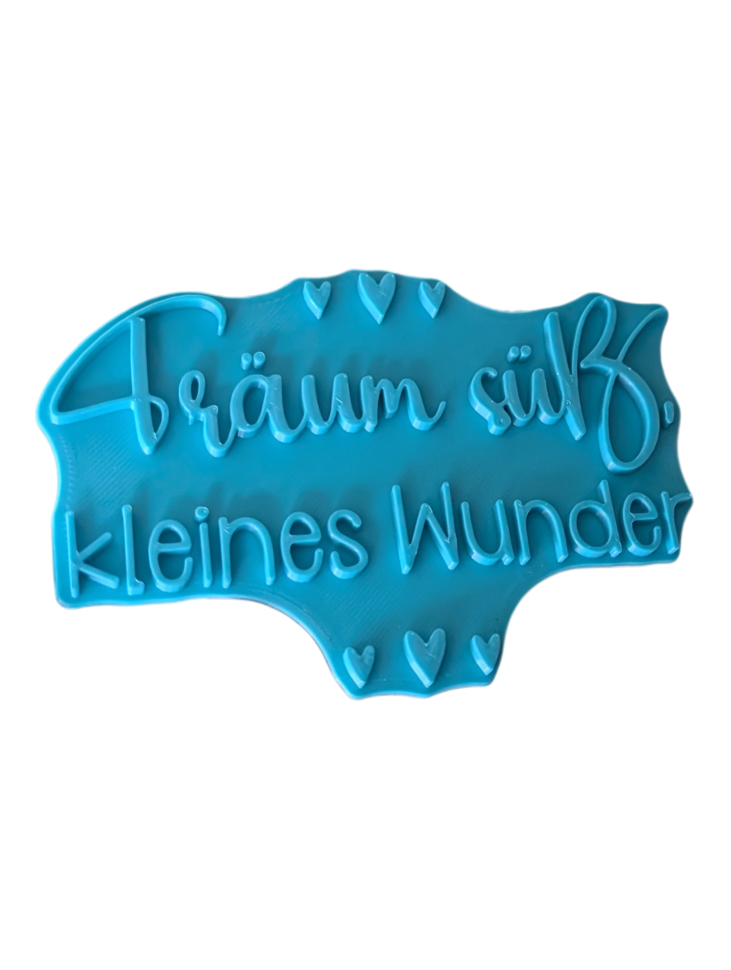 Schrägansicht des Tonstempels 'Träum süß, kleines Wunder'. Das Töpferwerkzeug aus türkisfarbenem Material besticht durch ein tiefes Relief für perfekte Abdrücke.