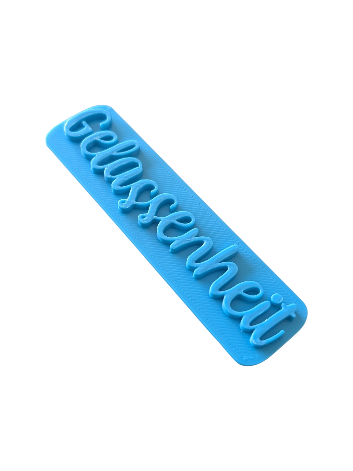 Perspektivische Detailansicht des blauen Stempels mit dem Schriftzug Gelassenheit für Töpferarbeiten.