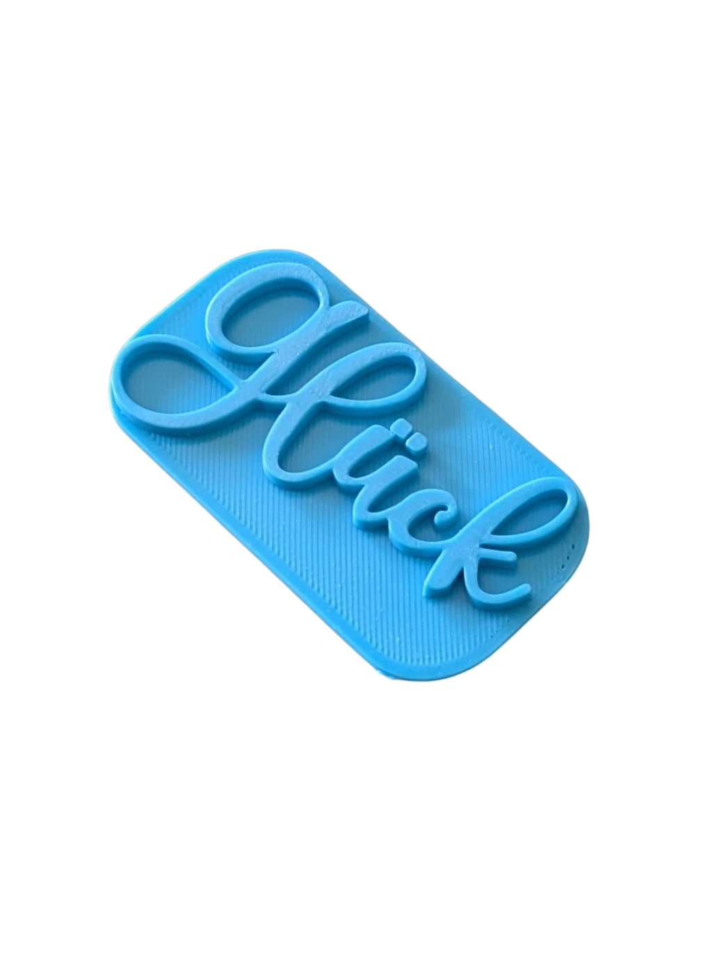 Perspektivische Detailansicht des blauen Stempels mit dem Schriftzug Glück für Töpferarbeiten.