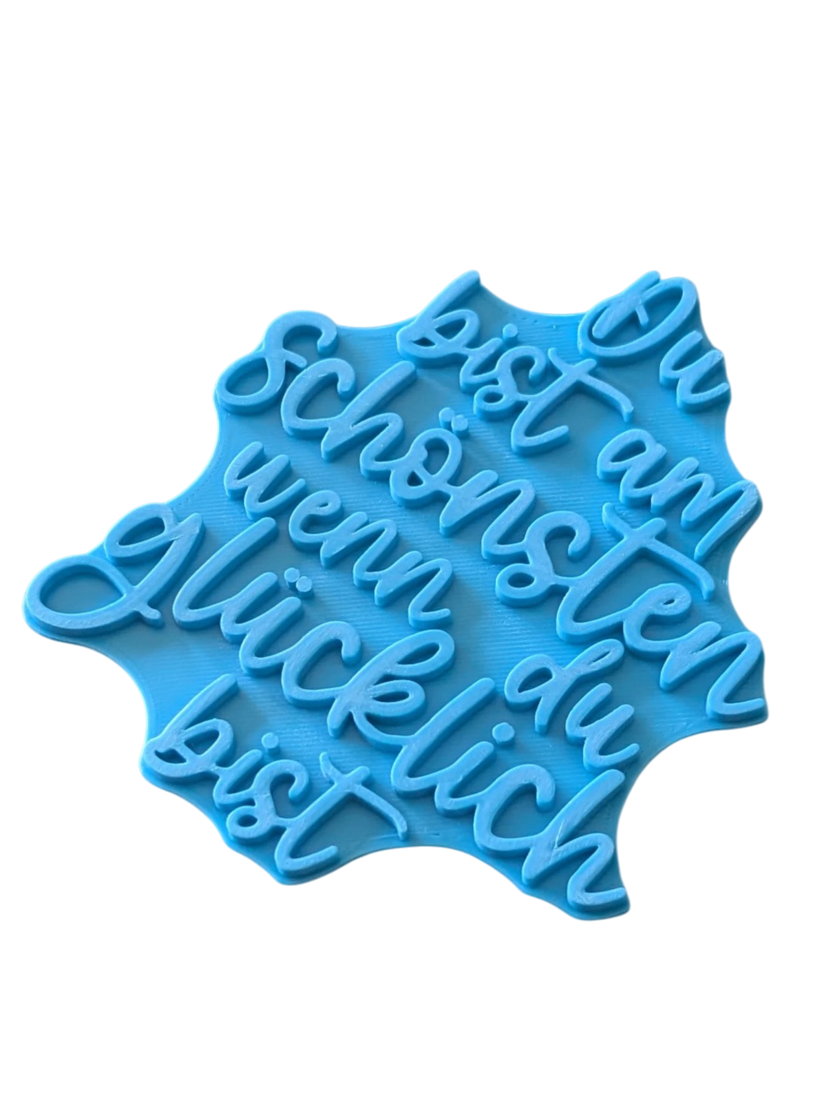 Perspektivische Detailansicht des blauen Stempels mit dem Spruch Du bist am Schönsten wenn du glücklich bist für Töpferarbeiten.