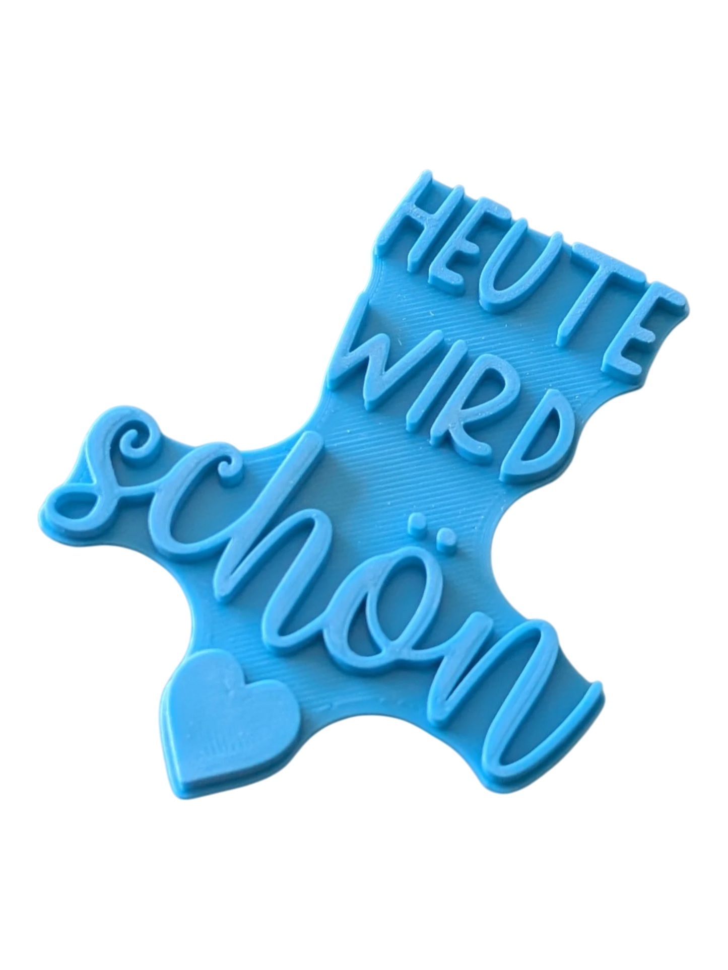 Perspektivische Detailansicht des blauen Keramikstempels mit dem Spruch Heute wird schön und Herz-Symbol.